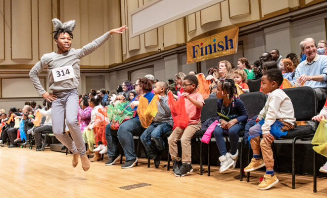 School children participate on stage as part of "Hare and the Tortoise" program