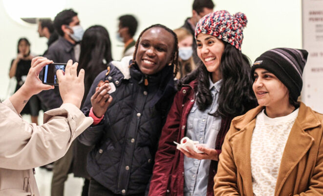 Patrons pose smiling in front of camera