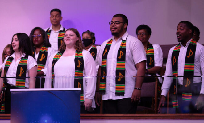 Chorus members standing and singing in church