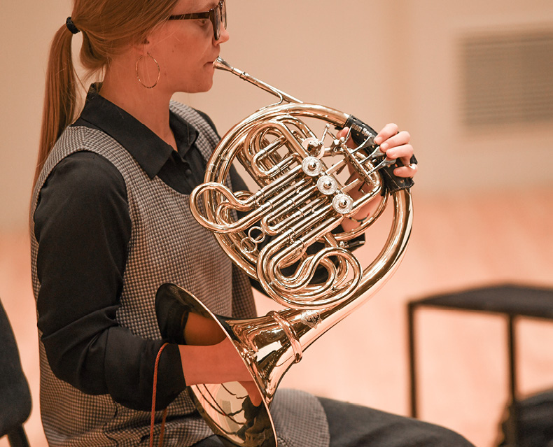 Close up of SLSO musician Victoria Knudtson playing the french horn