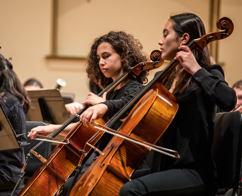 Youth Orchestra musicians playing the cello on stage