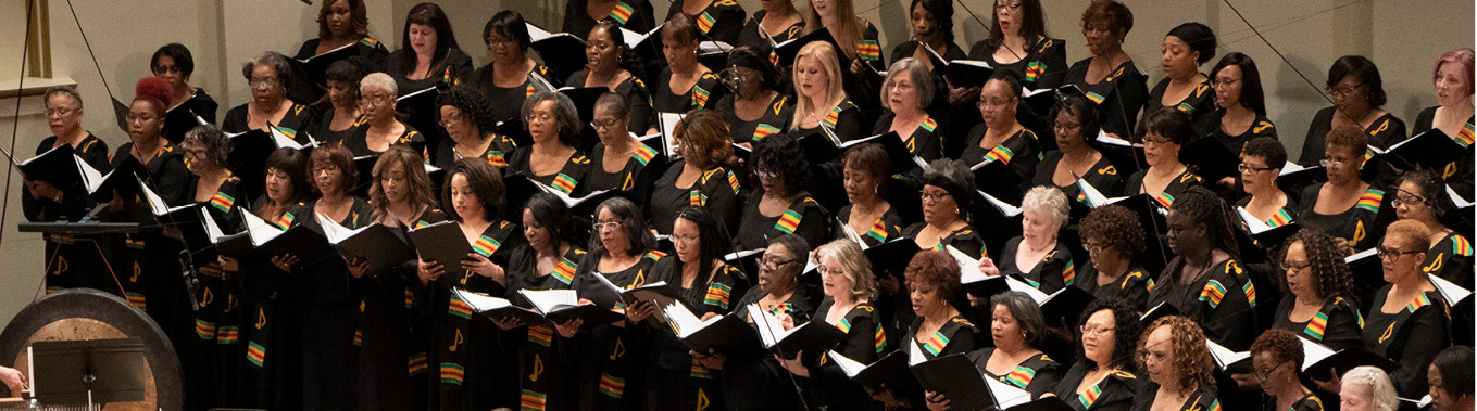 IN UNISON chorus members standing and singing on stage