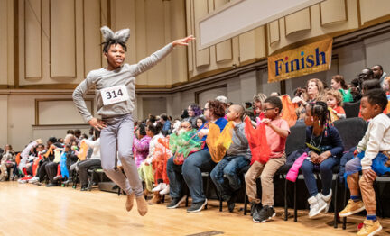 School children participate on stage as part of "Hare and the Tortoise" program