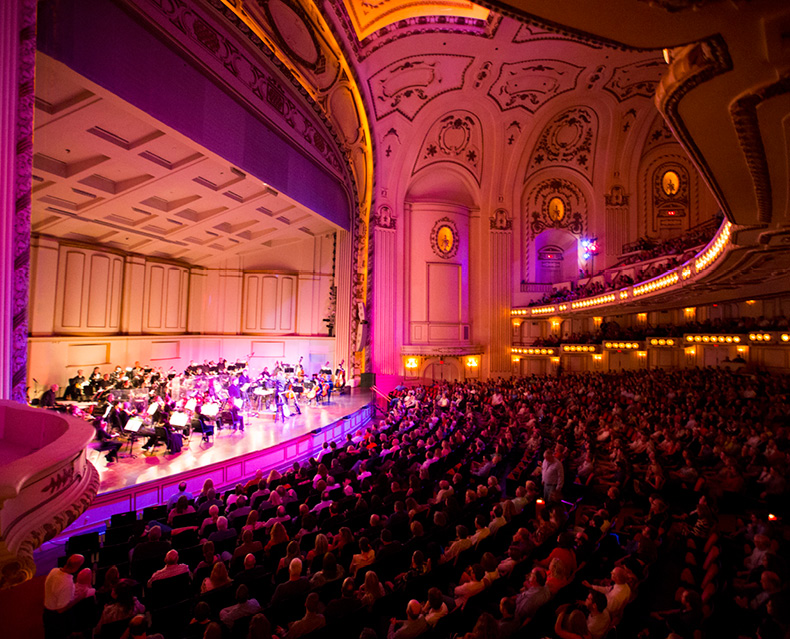 Wide shot of audiences watching musicians play on stage