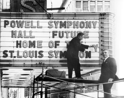 Black and white image of two men placing letters in marquee that say "Powell Symphony Hall Future Home of the St. Louis Symphony"