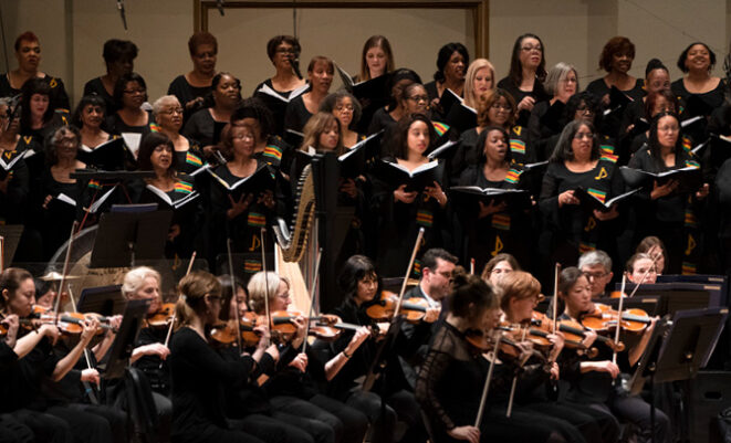 IN UNISON Chorus members standing and singing on stage