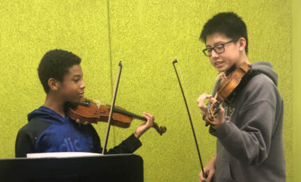 Two young musicians playing together as part of Peer to Peer program