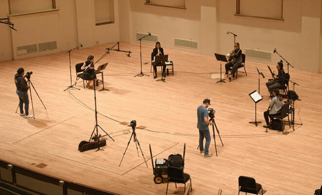 SLSO musicians playing in a circle on stage with microphones surrounding them