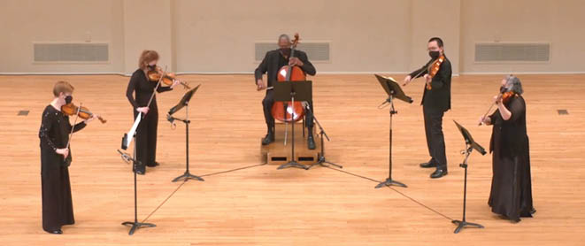 Five SLSO musicians playing their string instruments on stage