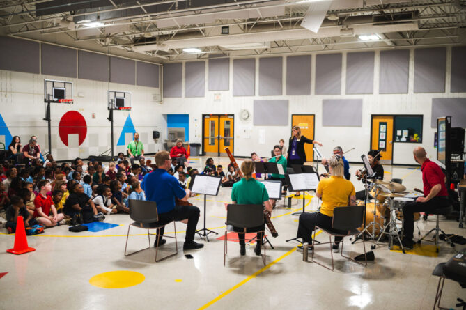 SLSO musicians playing for elementary age students at an Acoustic Music Project event