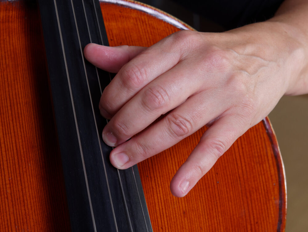 Cellist playing with thumb on fingerboard